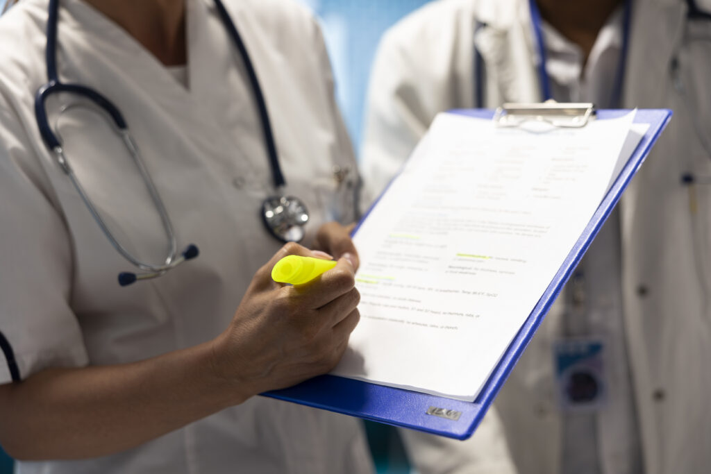 general practitioner highlighting important test results on hospital records